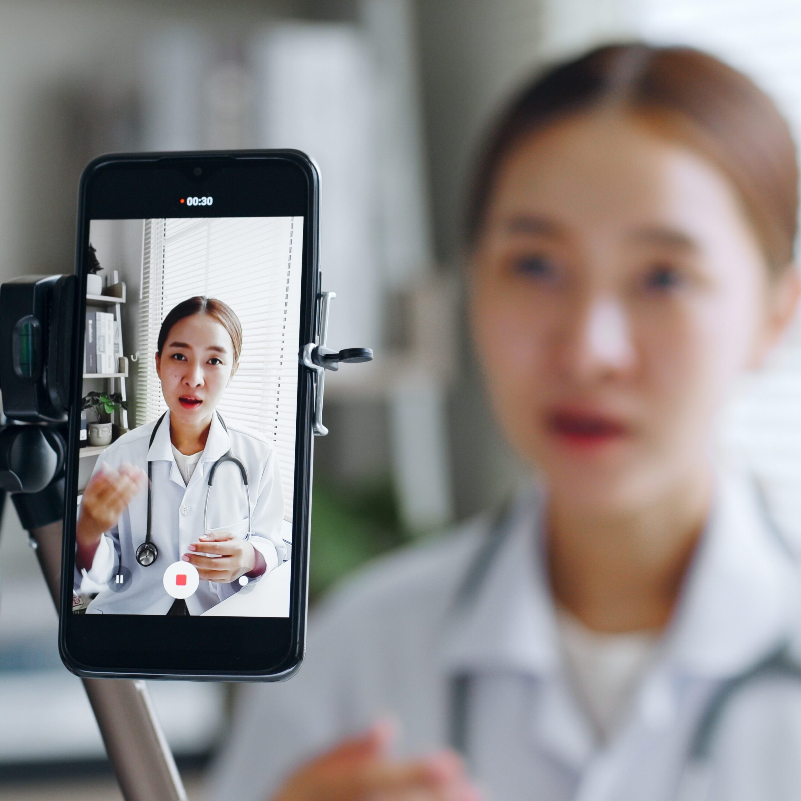 Young Doctor Recording Themselves on a Phone Attached to a Tripod