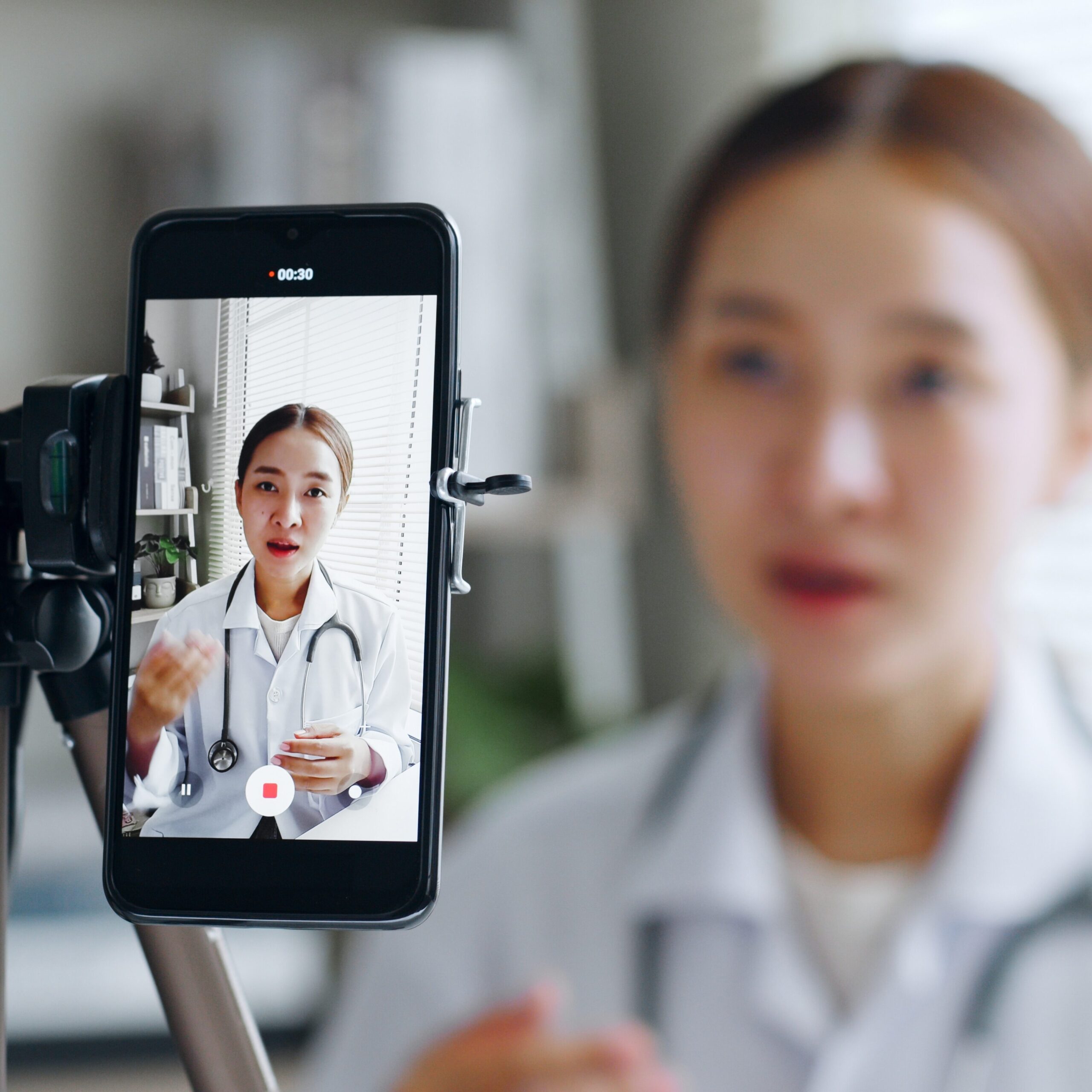 Young Doctor Recording Themselves on a Phone Attached to a Tripod